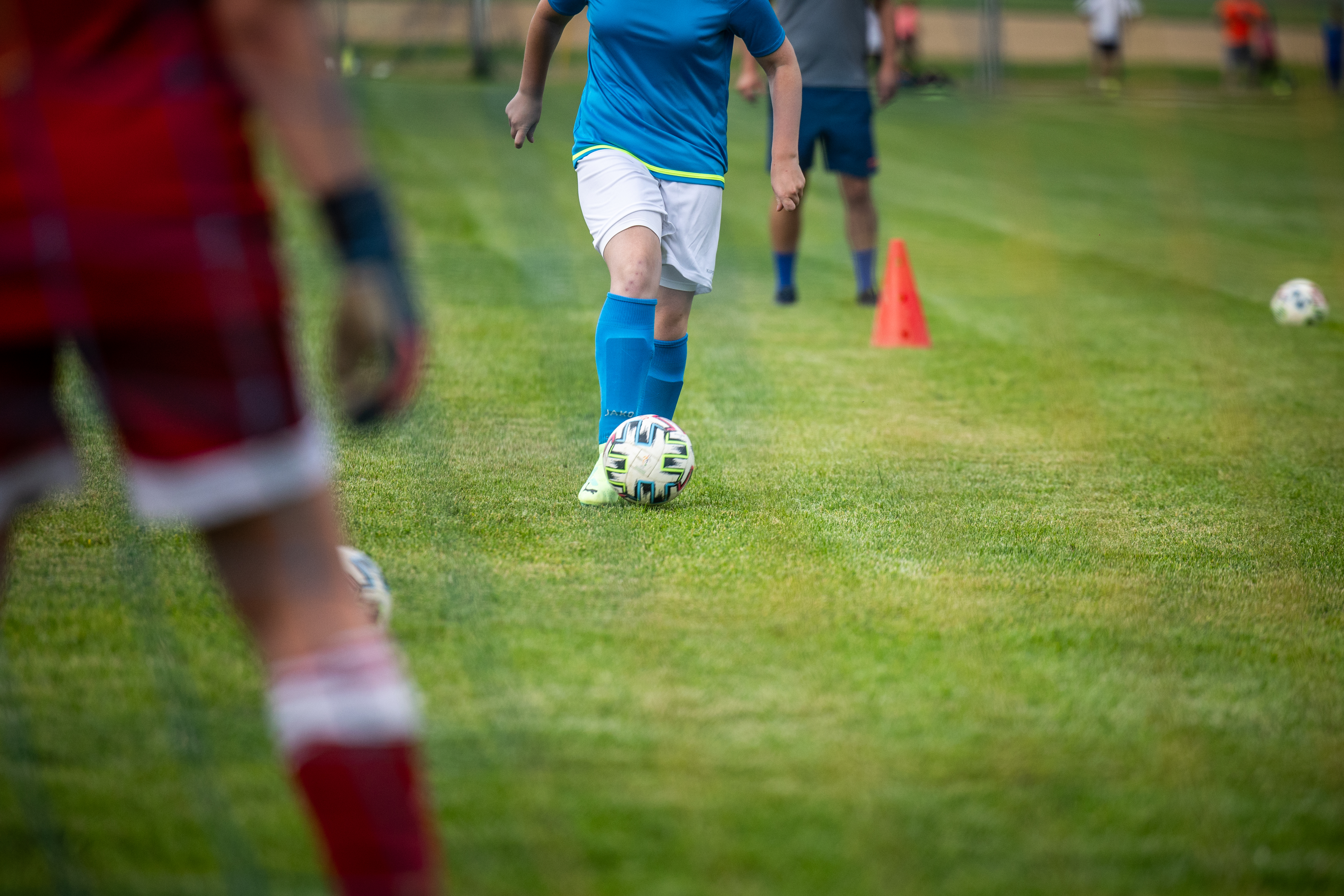 Personne de face jouant au football s'avance vers le goal avec le gardien de dos