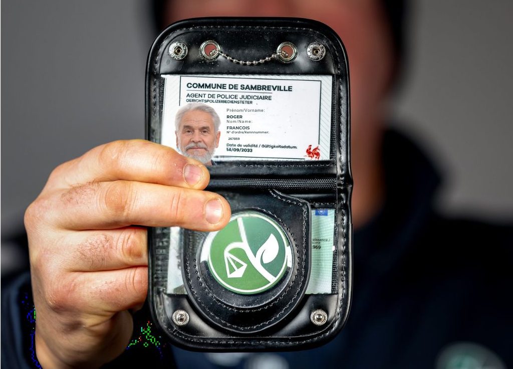 un homme présente sa carte qui est contenu dans un étui en cuir